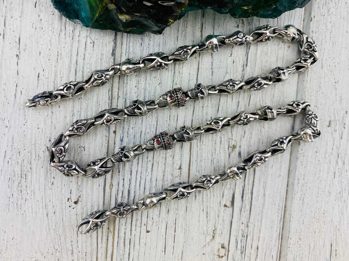 Fleur de lis skull chain laid straight, showing alternating links