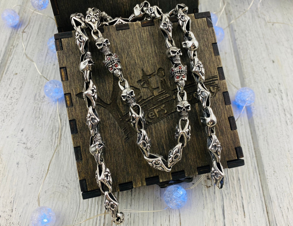 Fleur de lis skull chain hanging over a wooden gift box