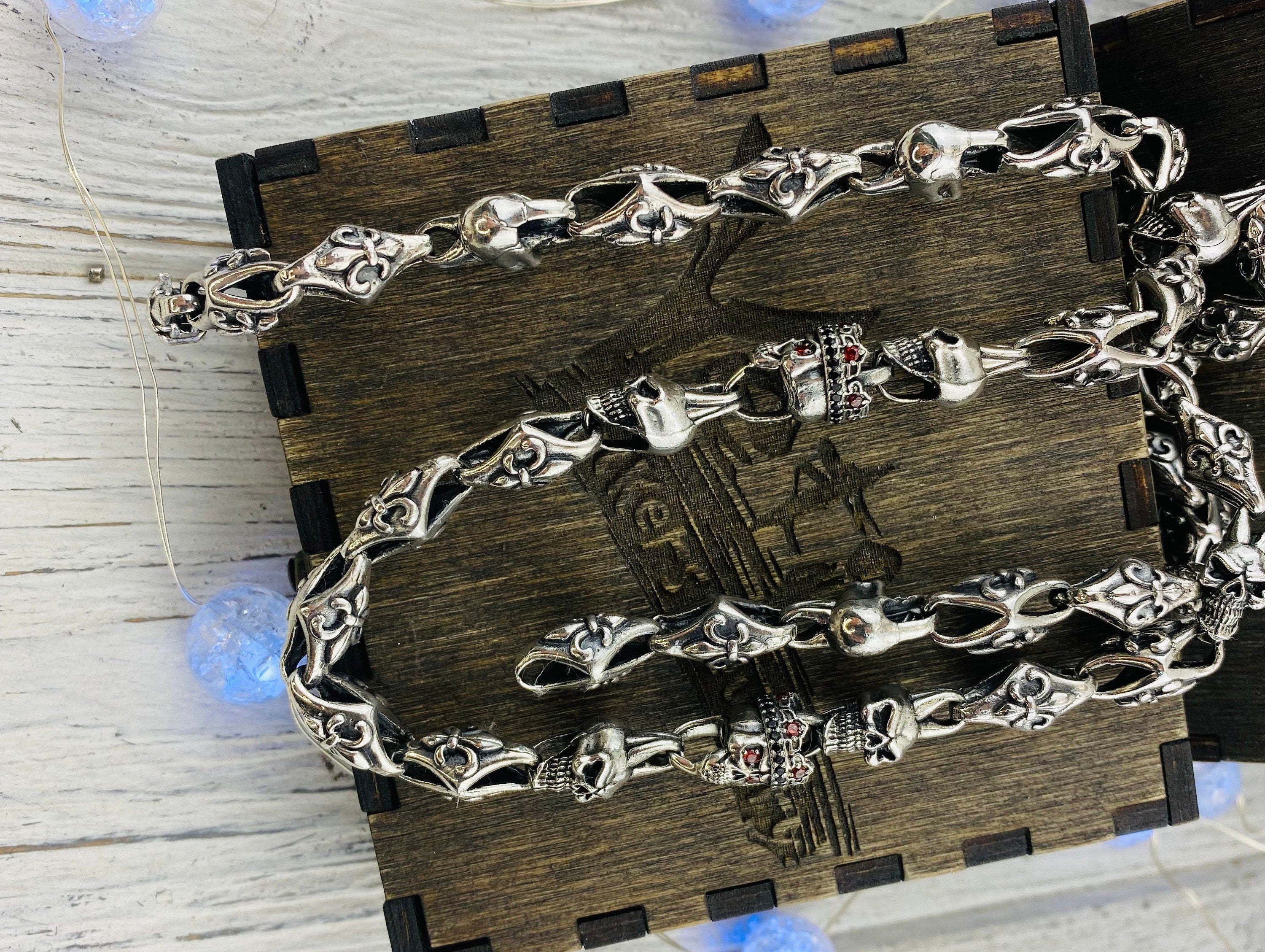 Heavy silver skull chain draped across a wooden box