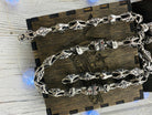 Heavy silver skull chain draped across a wooden box