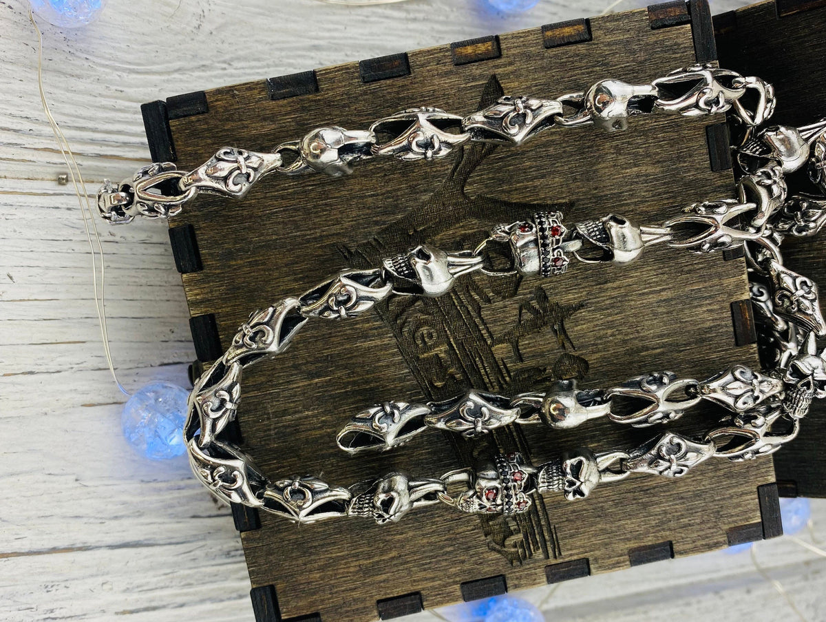 Heavy silver skull chain draped across a wooden box