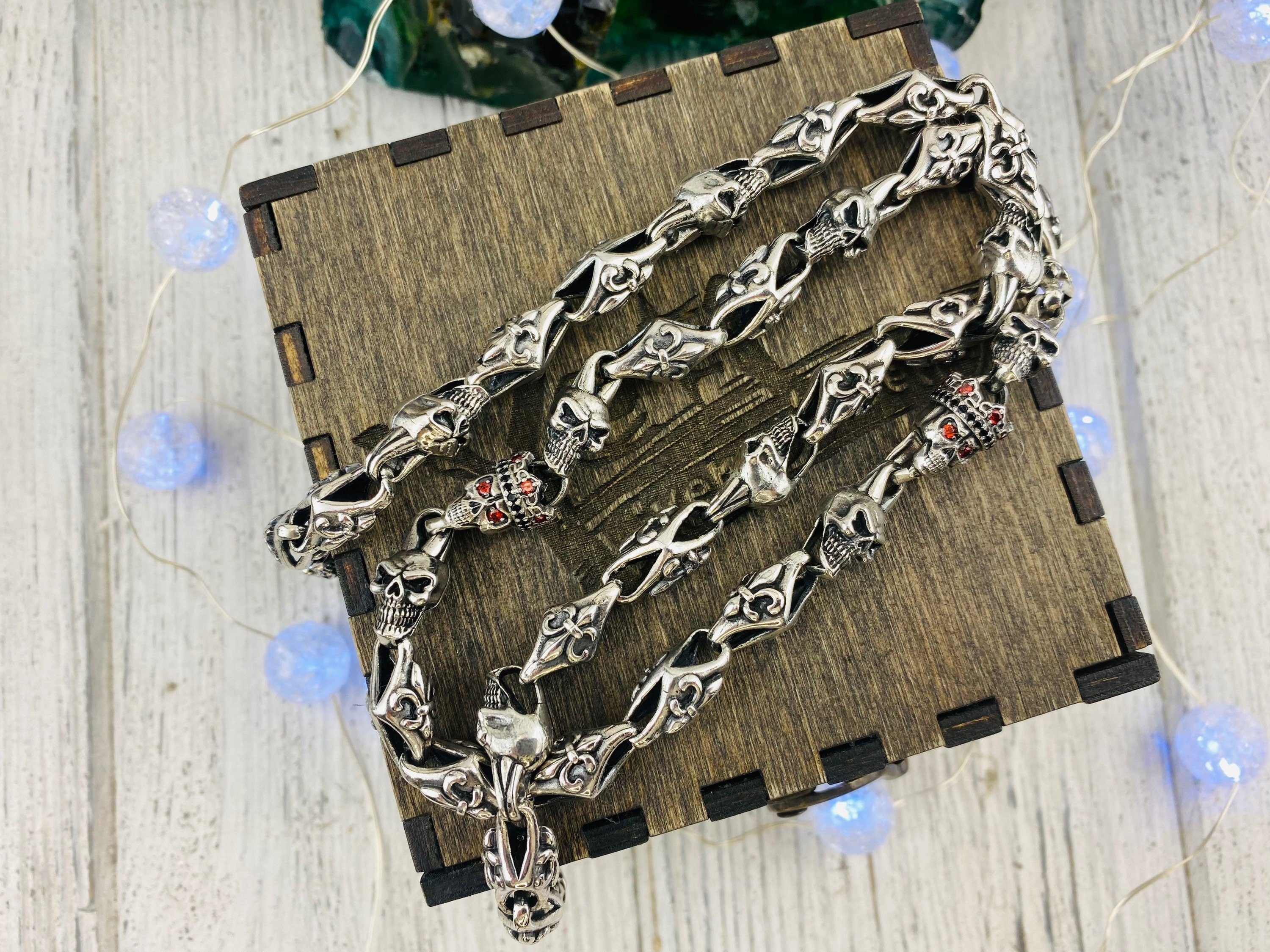 Fleur de lis skull chain in a loose loop on a wooden box