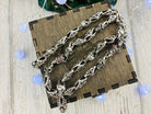 Fleur de lis skull chain in a loose loop on a wooden box