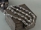 Fleur de lis crowned skull silver chain draped over a wooden box