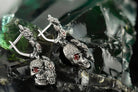 Floral Frida skull drop earrings with red stone eyes and rose leverbacks, close-up