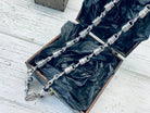 Forcer chain in a box on black paper, angled view