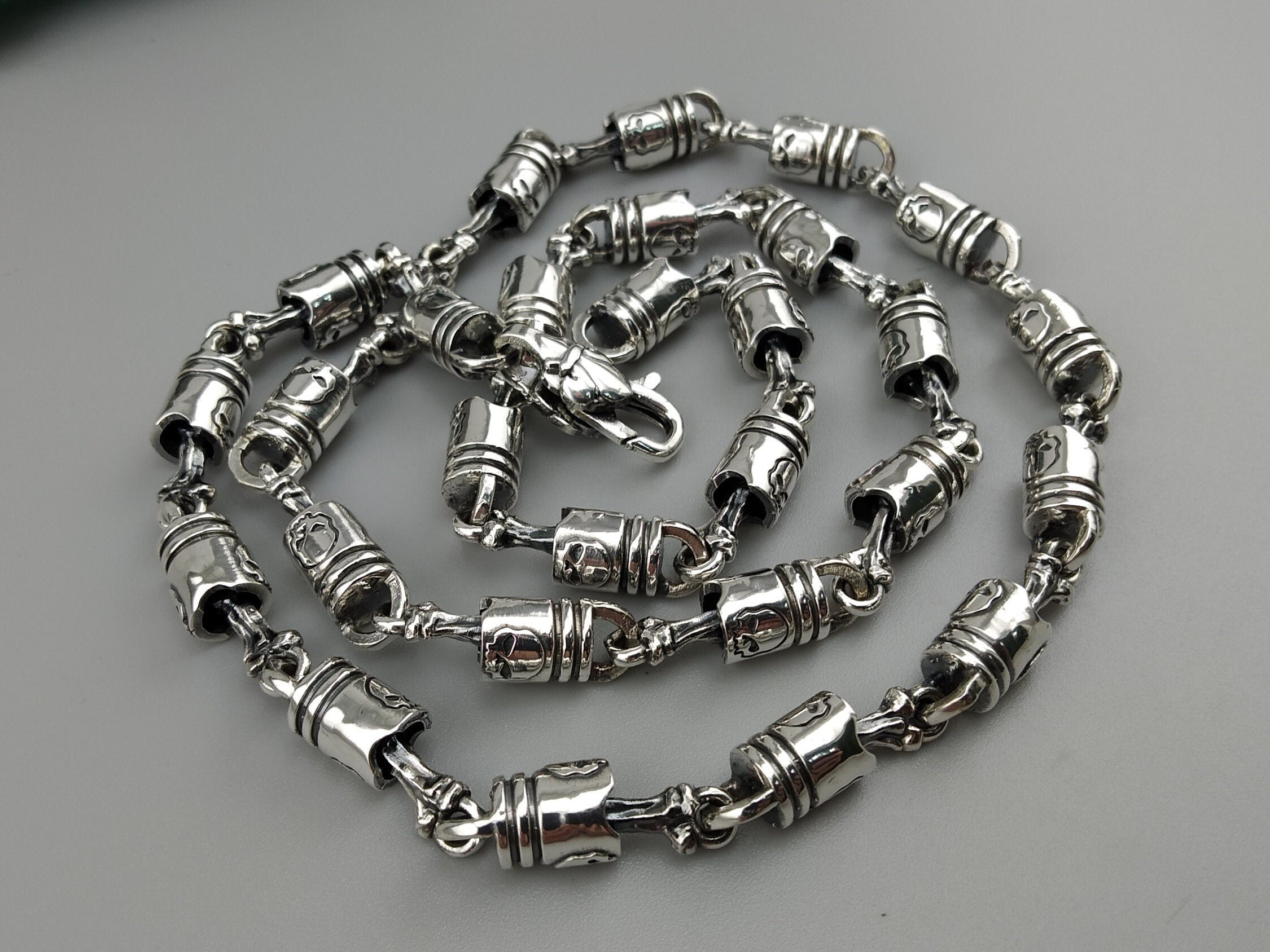 Forcer silver chain coiled on a light background, full view of the barrel links