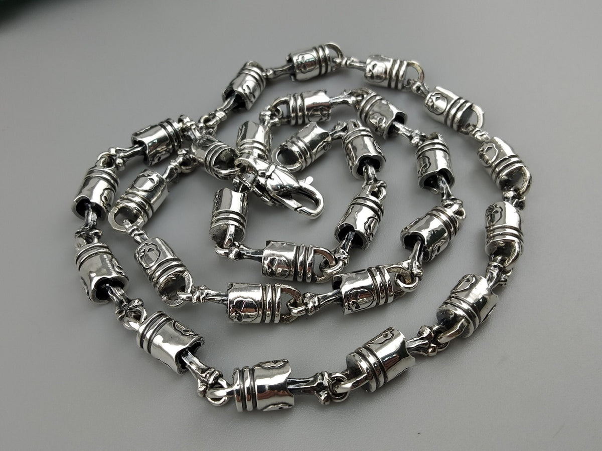 Forcer silver chain coiled on a light background, full view of the barrel links