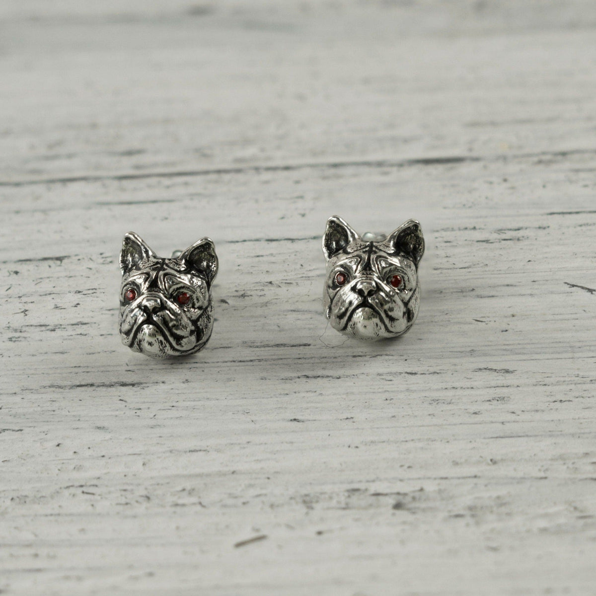 French bulldog sterling silver stud earrings on white wood, front view
