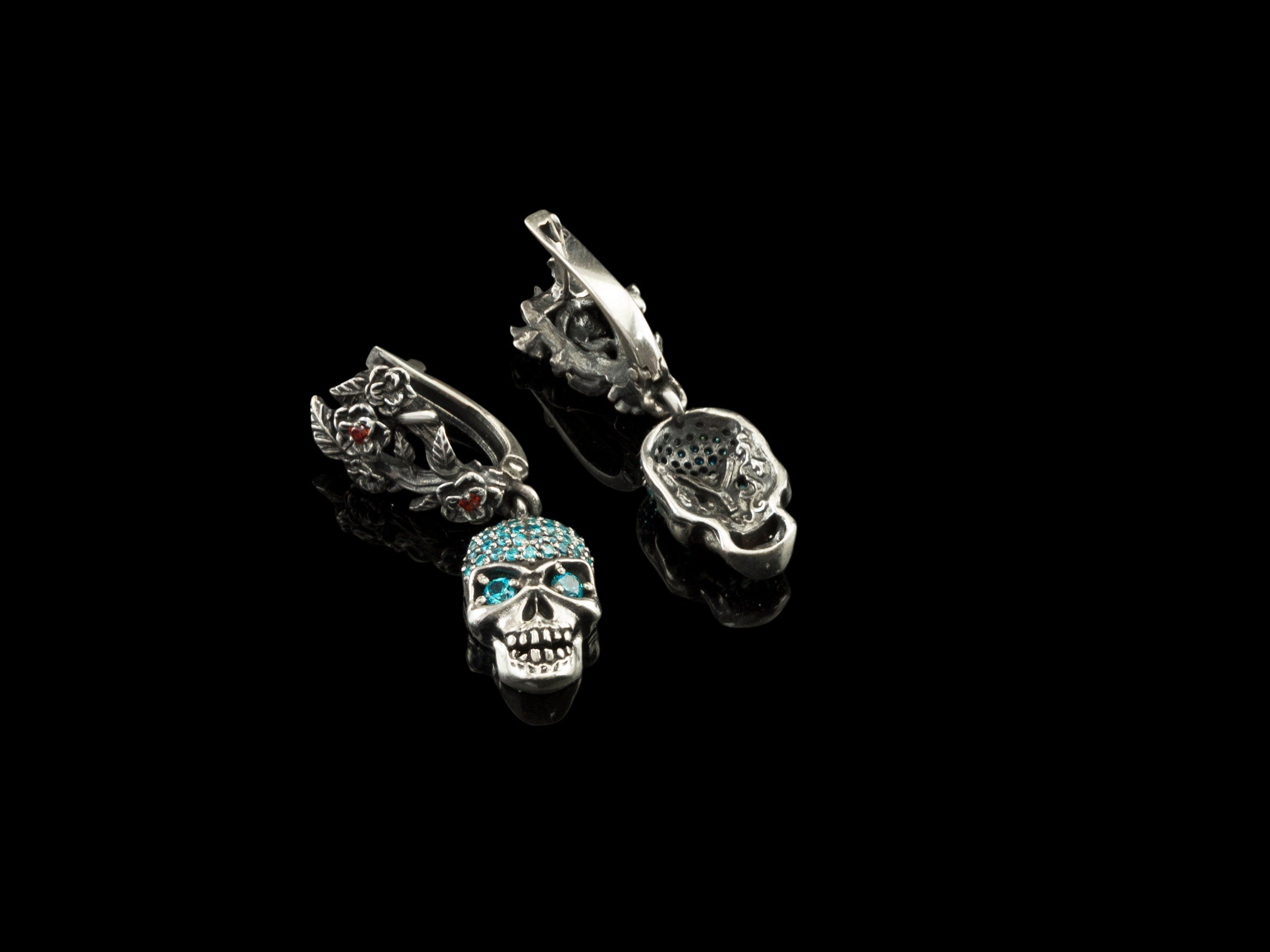 Frida Light blue CZ skull earrings with one floral leverback open, on black