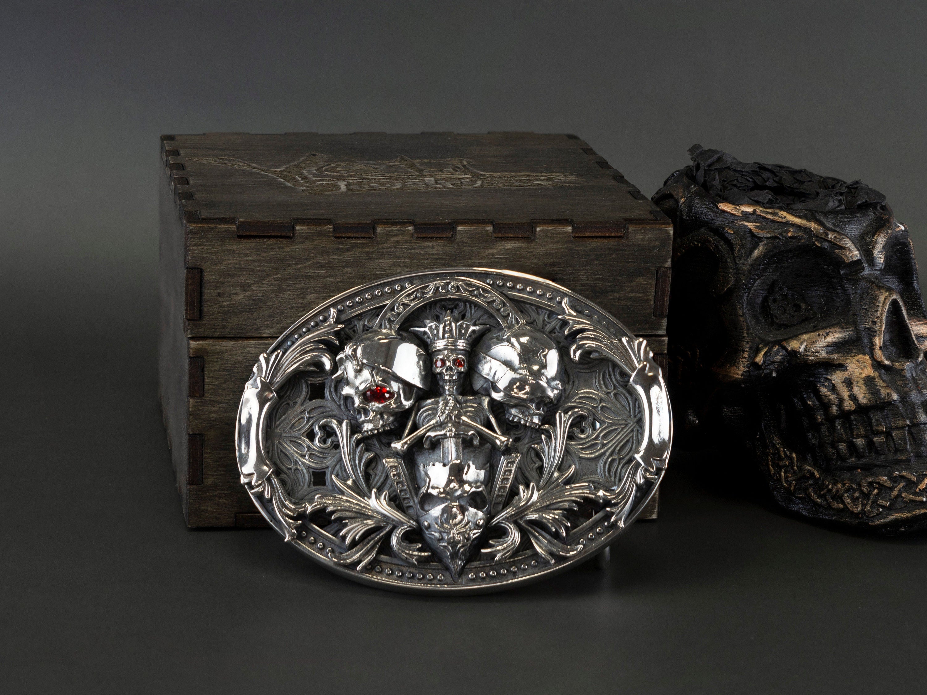 Skull belt buckle on a wooden box with the leather belt