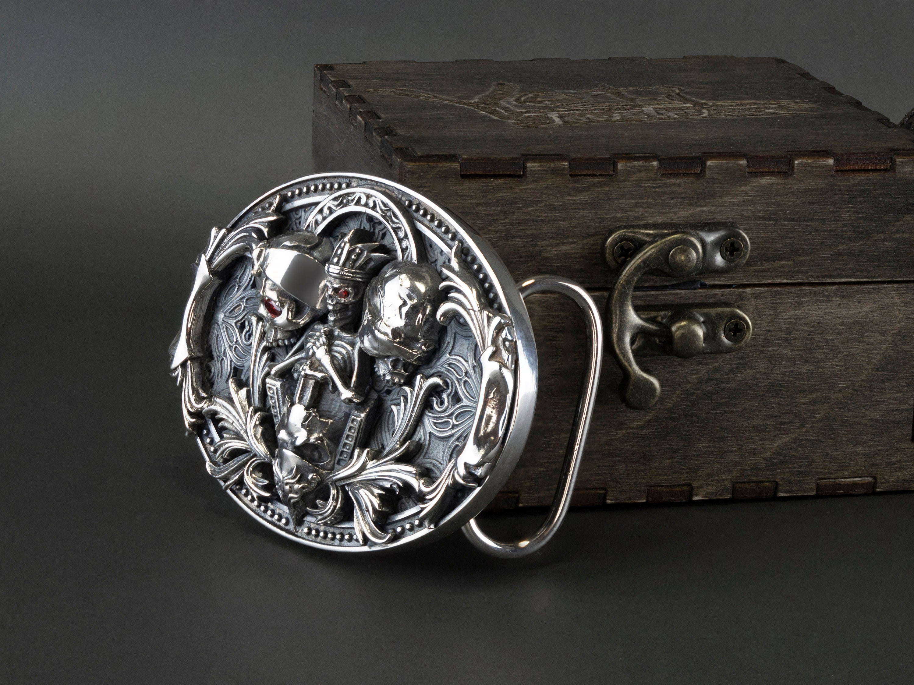 Close-up of the three sculpted skulls and scrollwork on the silver buckle