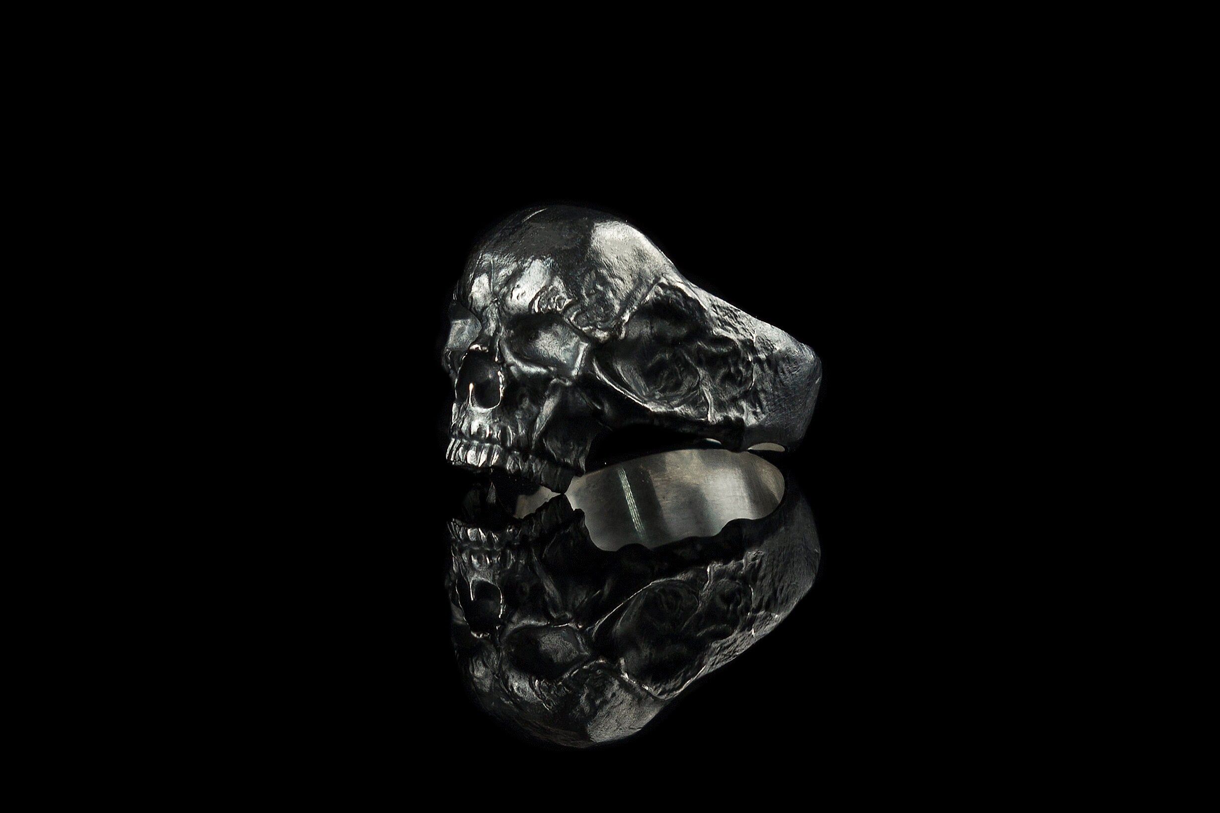 Hellbound skull biker ring, left side view showing cracked texture and smooth inner band