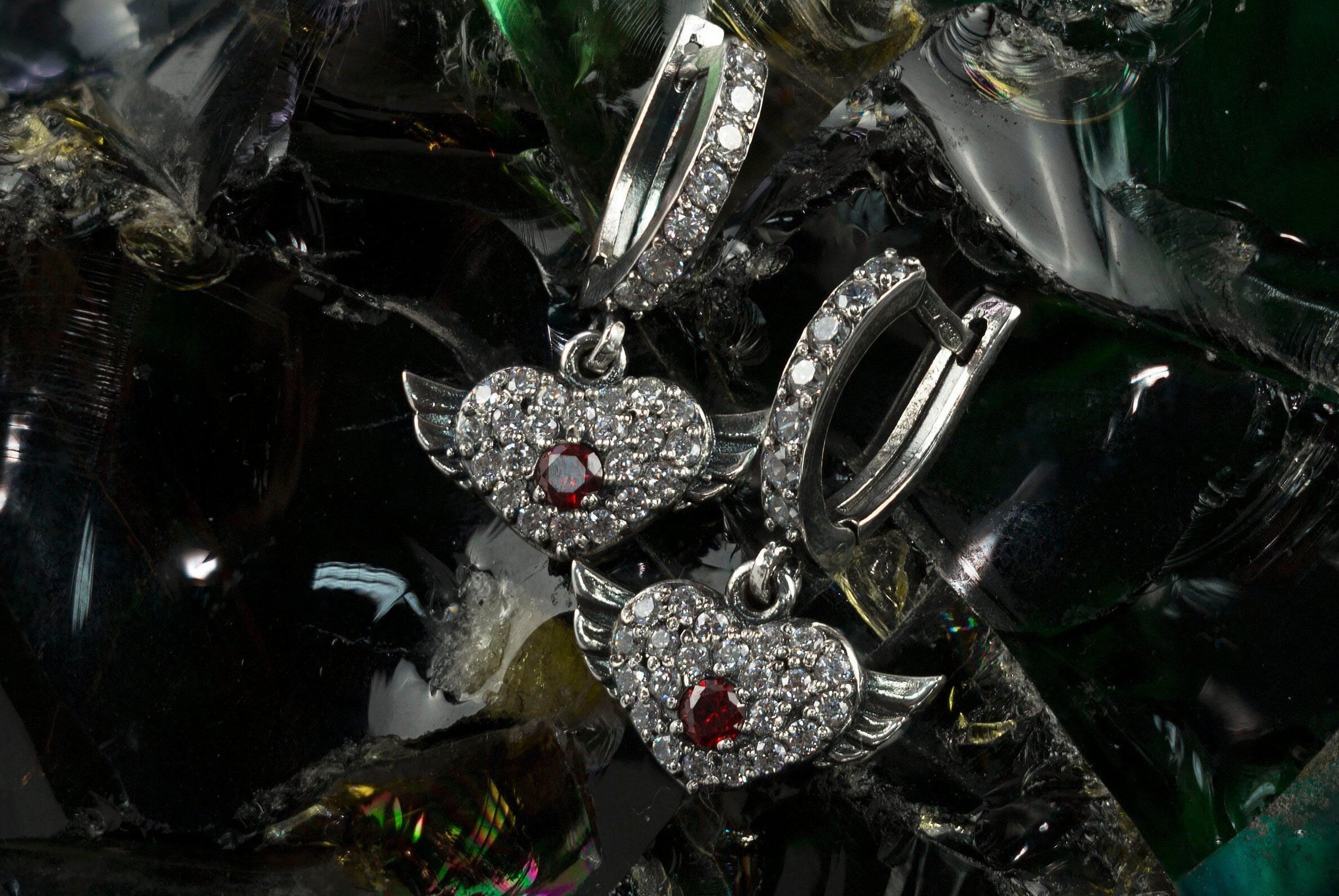 Winged heart earrings in 925 sterling silver with red cubic zirconia center stones and clear CZ accents