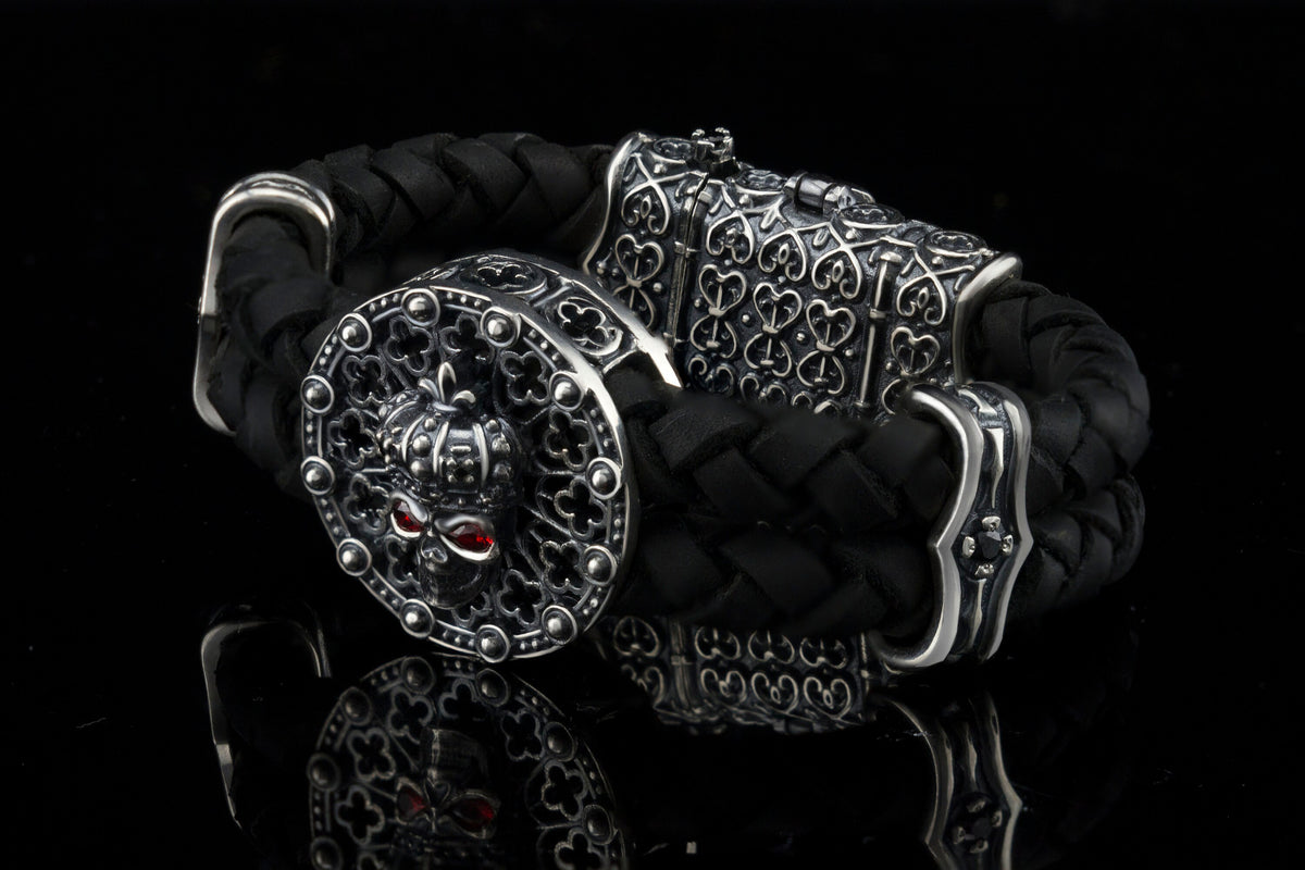 Crowned skull bracelet with 925 sterling silver details, genuine black braided leather and red cubic zirconia eyes