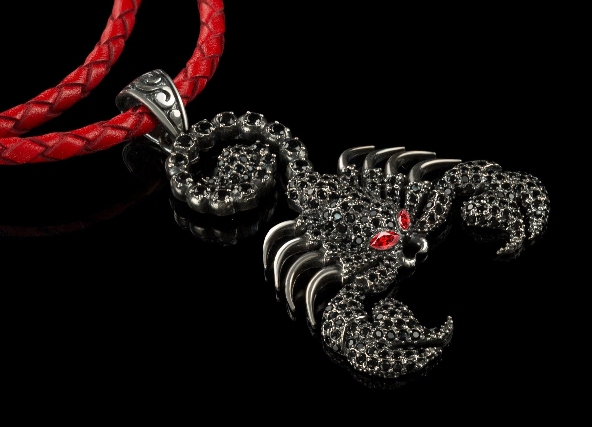 Scorpion Emperor black pendant in 925 sterling silver with dark cubic zirconia stones, red eyes, and a braided leather cord.