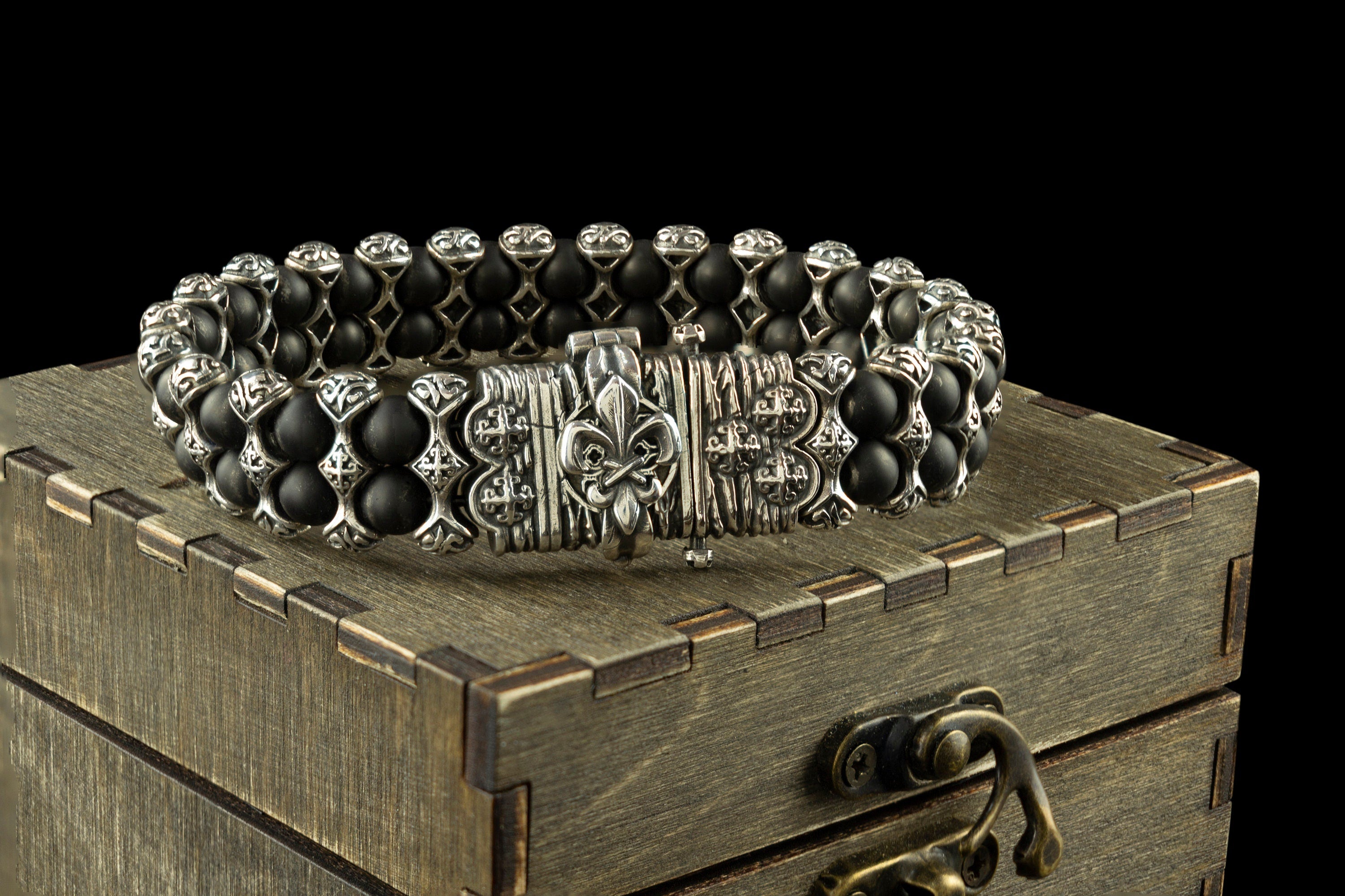 Saint Victor bracelet with black onyx beads and ornate 925 sterling silver details displayed on a wooden gift box by Yeti Jewelry