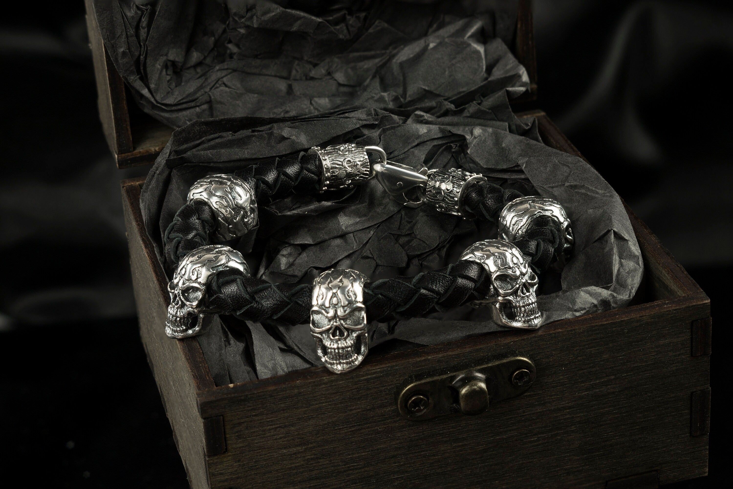 Wild 925 sterling silver skull bracelet with braided black leather band and multiple sculptural skulls
