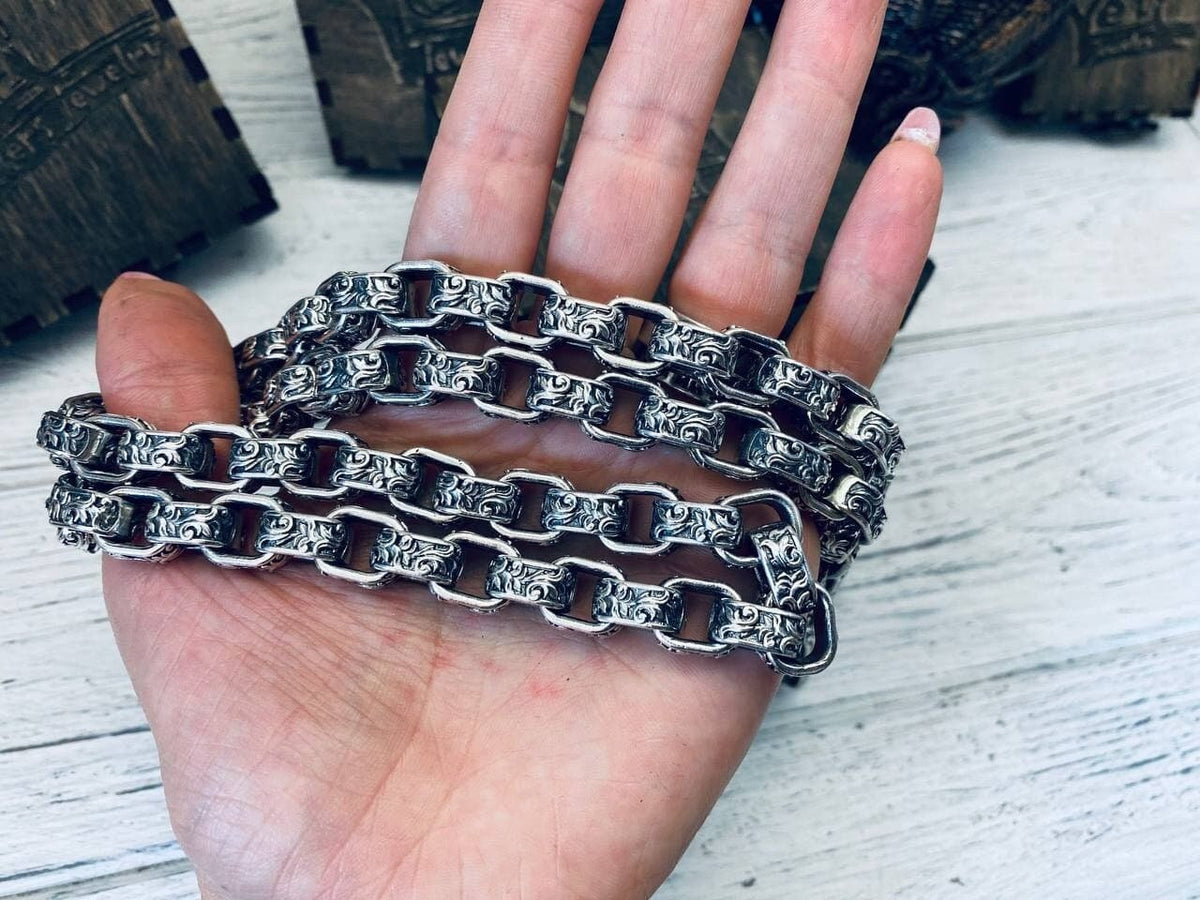 Rory heavy 925 sterling silver chain necklace with ornate interlocking links and oxidized detailing, displayed across a hand to show its scale.