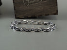 Heavy 925 sterling silver chain bracelet with polished interlocking links and a decorative clasp, displayed on a gray background beside a Yeti Jewelry wooden box.