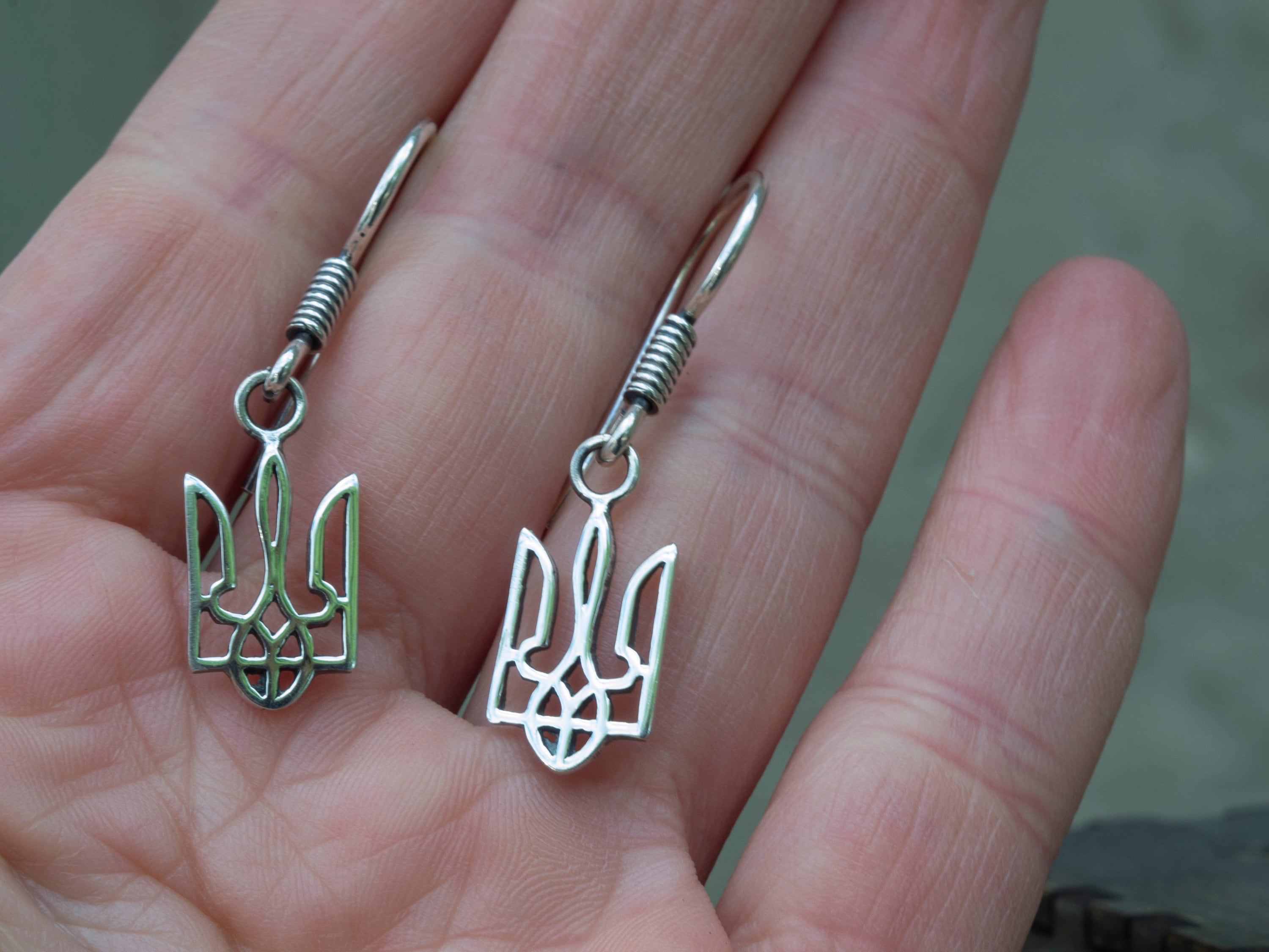 Close-up of minimalist 925 sterling silver Tryzub earrings showing the openwork Ukrainian trident design