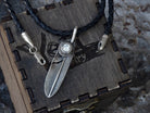 Textured Feather pendant in 925 sterling silver with a round cubic zirconia setting, shown with a black braided leather cord on a wooden Yeti Jewelry box.