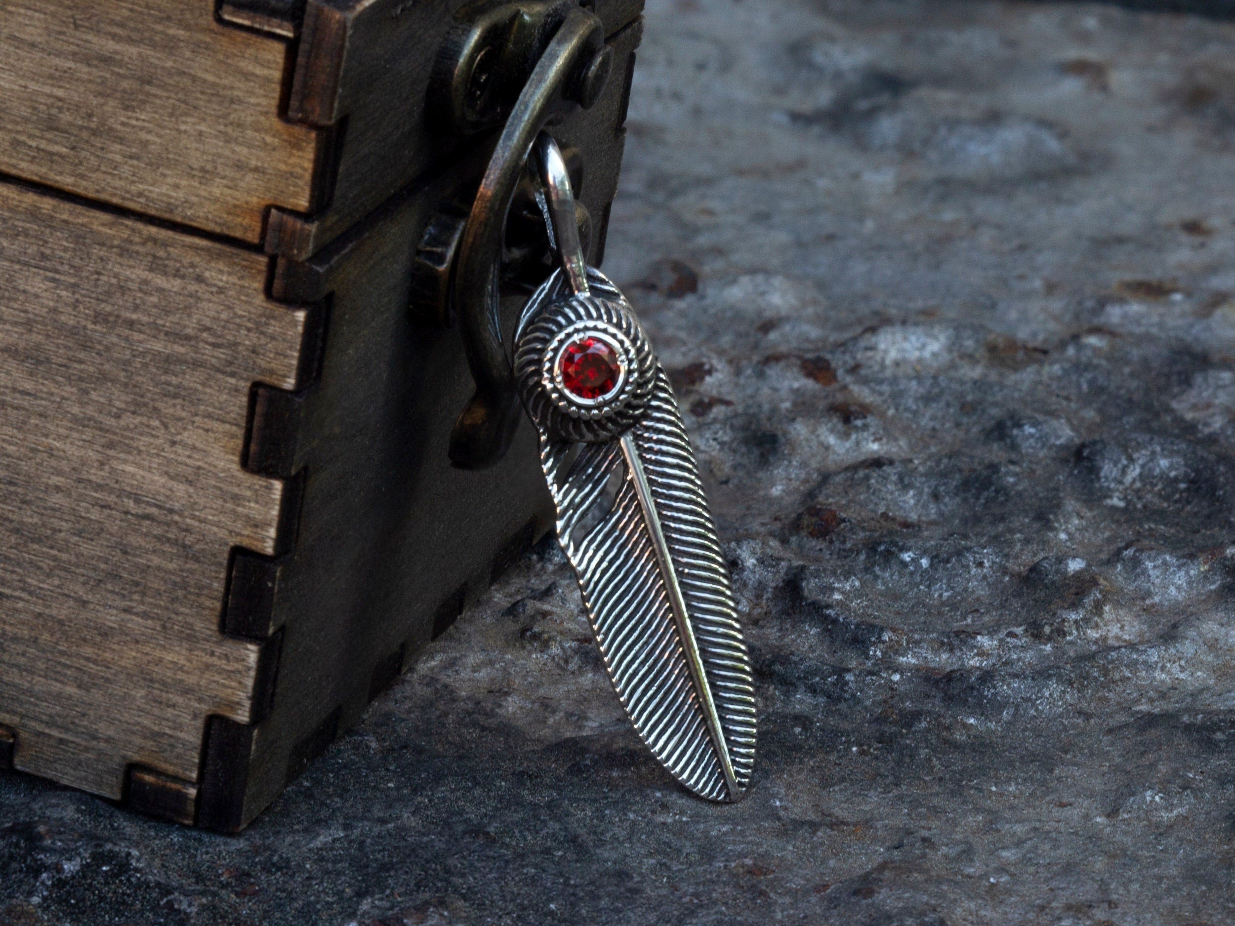 925 sterling silver feather pendant with red cubic zirconia and detailed feather texture