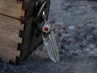 925 sterling silver feather pendant with red cubic zirconia and detailed feather texture