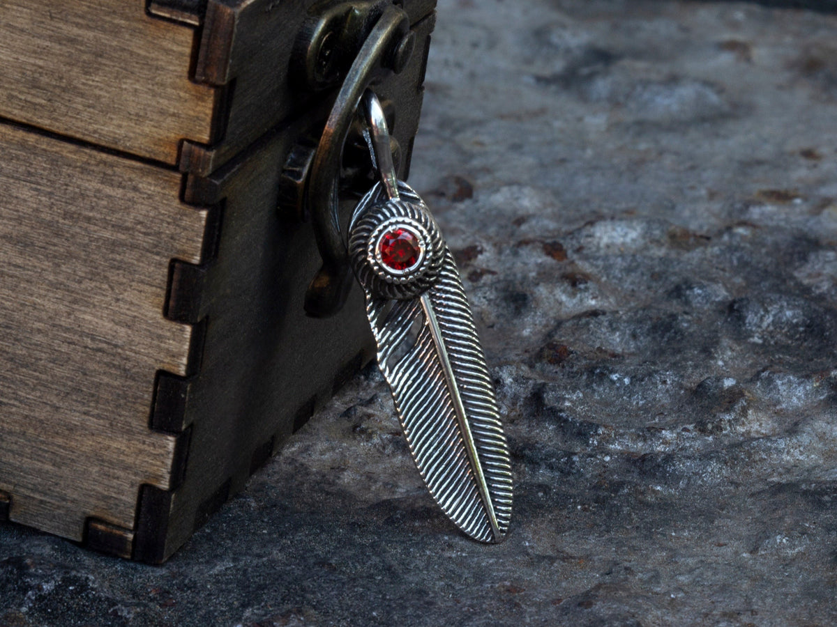925 sterling silver feather pendant with red cubic zirconia and detailed feather texture