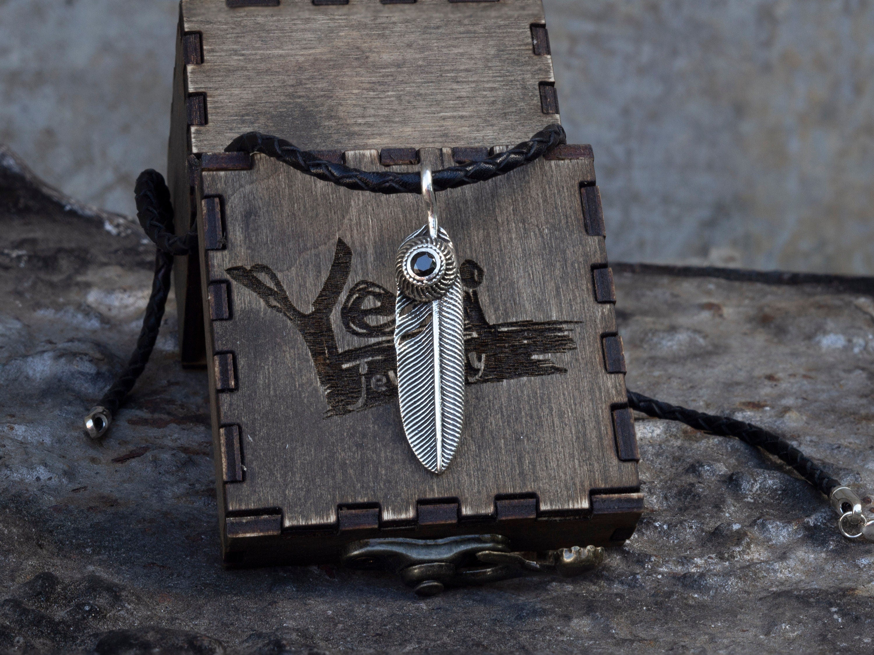 925 sterling silver feather pendant with detailed textured design and decorative stone