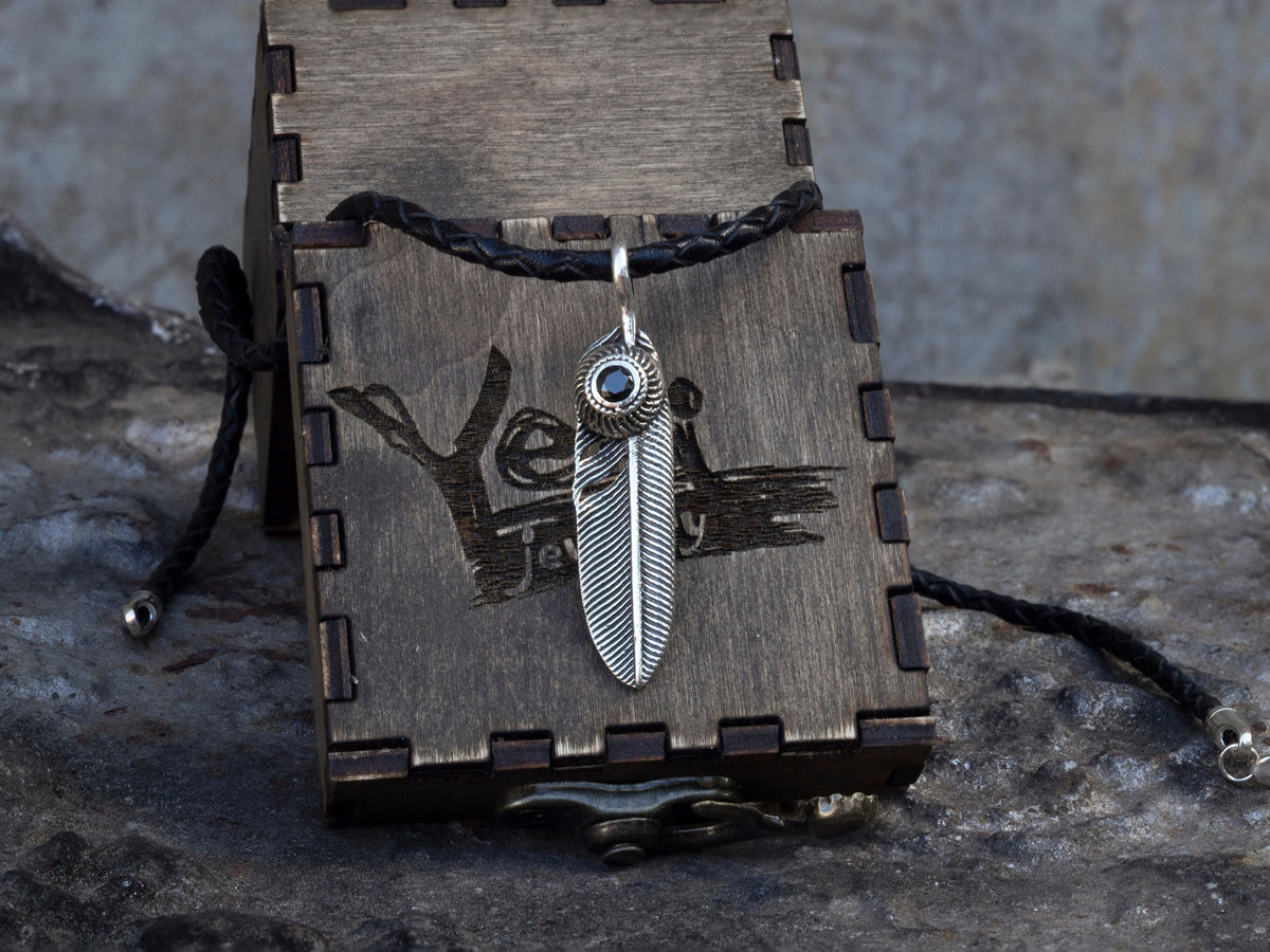 925 sterling silver feather pendant with detailed textured design and decorative stone