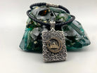 Mosque and Crescent pendant necklace in textured 925 sterling silver with gold accents and cubic zirconia, paired with a black leather cord featuring silver inlays.