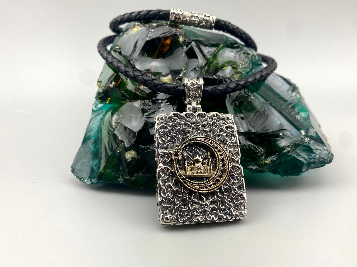 Mosque and Crescent pendant necklace in textured 925 sterling silver with gold accents and cubic zirconia, paired with a black leather cord featuring silver inlays.