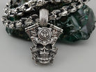 Vigor V-Twin skull pendant in 925 sterling silver with an ornamental fleur-de-lis-inspired emblem and sculpted mechanical details, photographed with a silver biker chain.