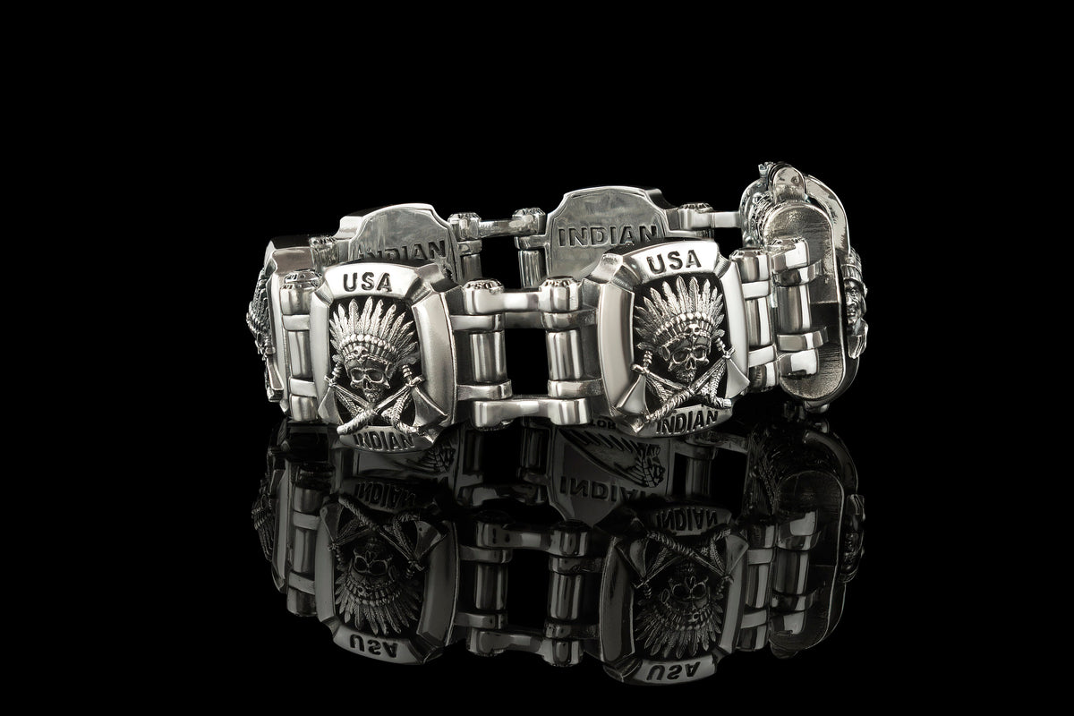 Indian bracelet laid out on black, linked silver plates with geometric pattern
