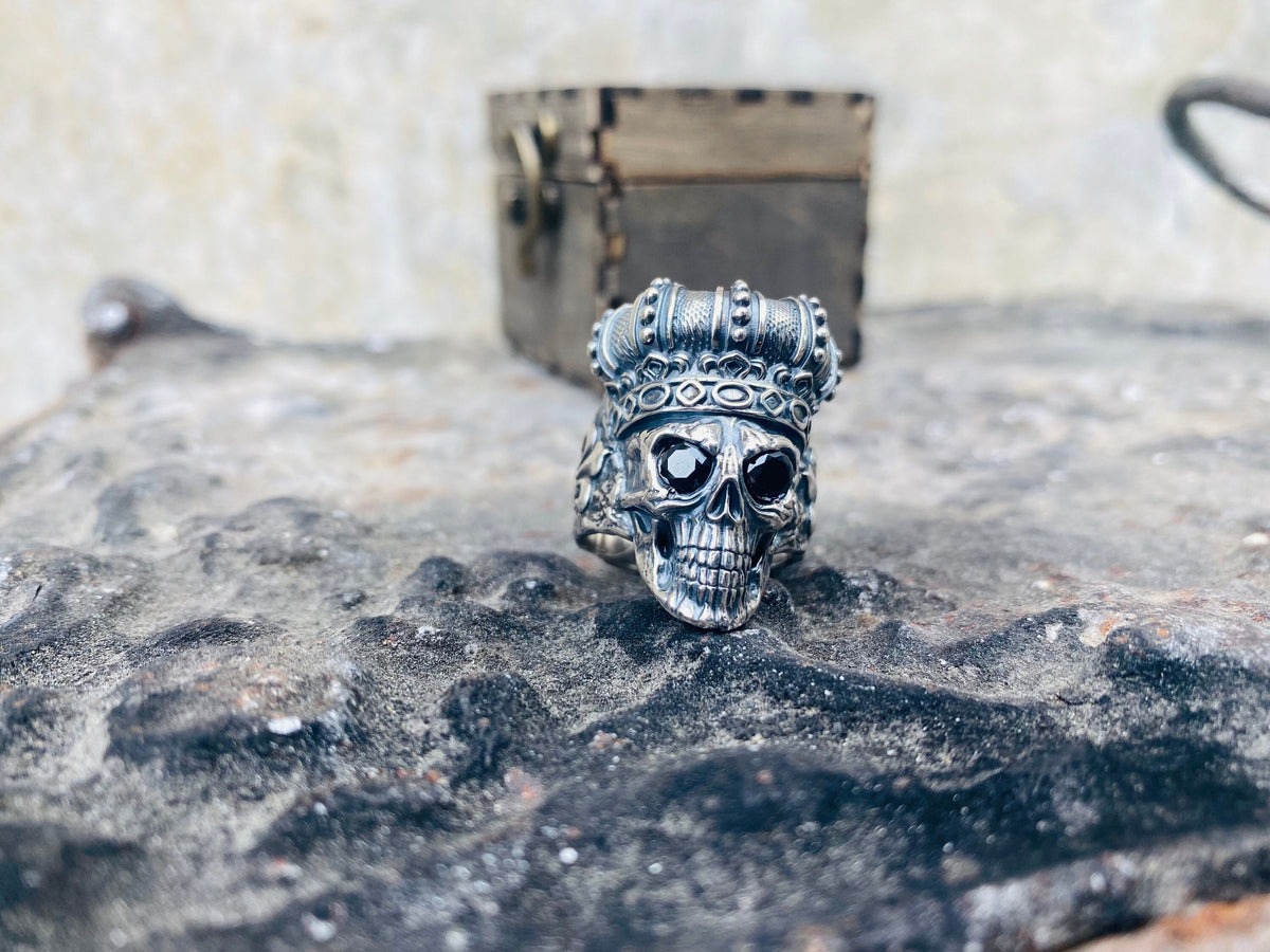 King of Shadow crowned skull sterling silver ring on a wooden box