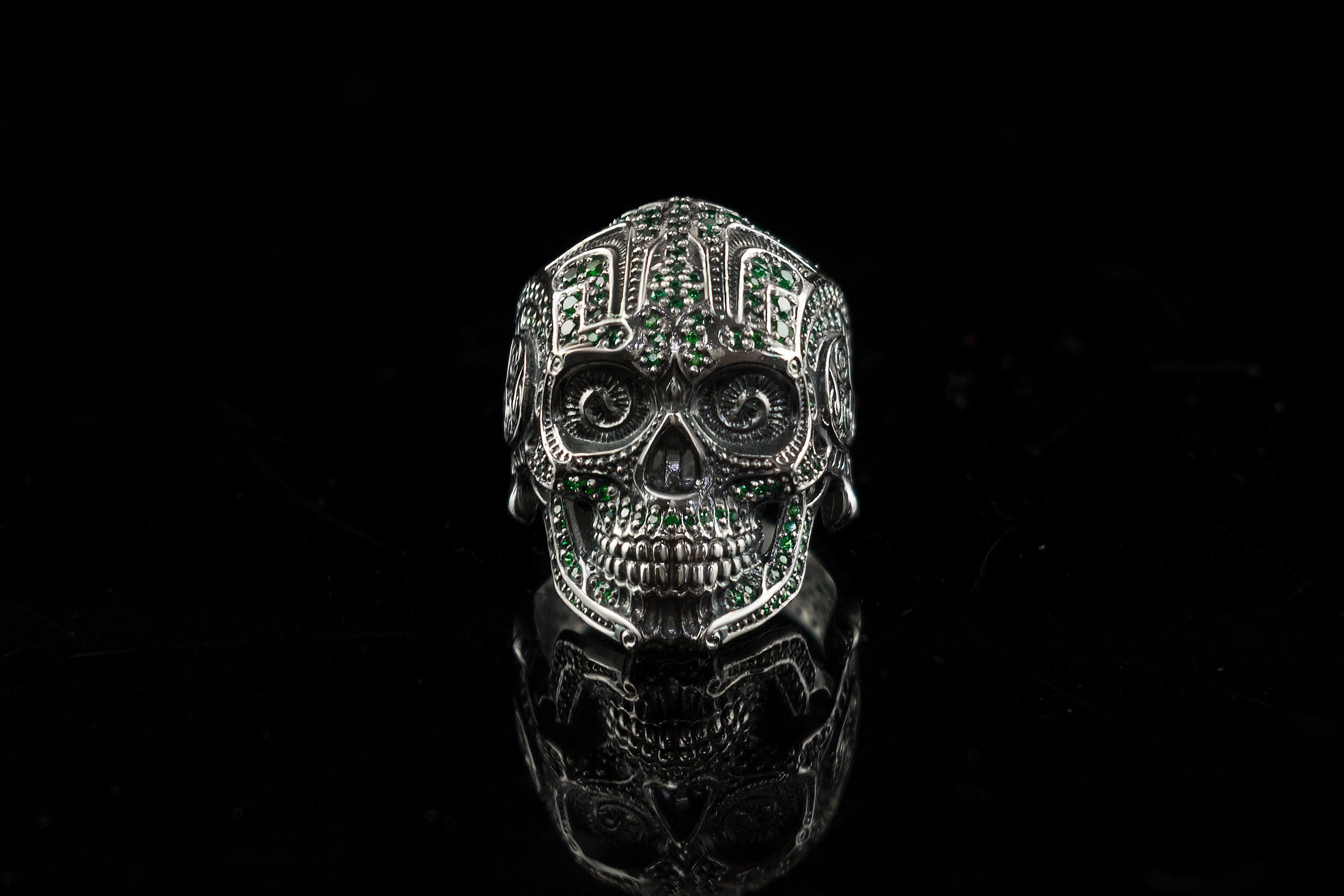 Sugar skull silver ring with green stones, front view