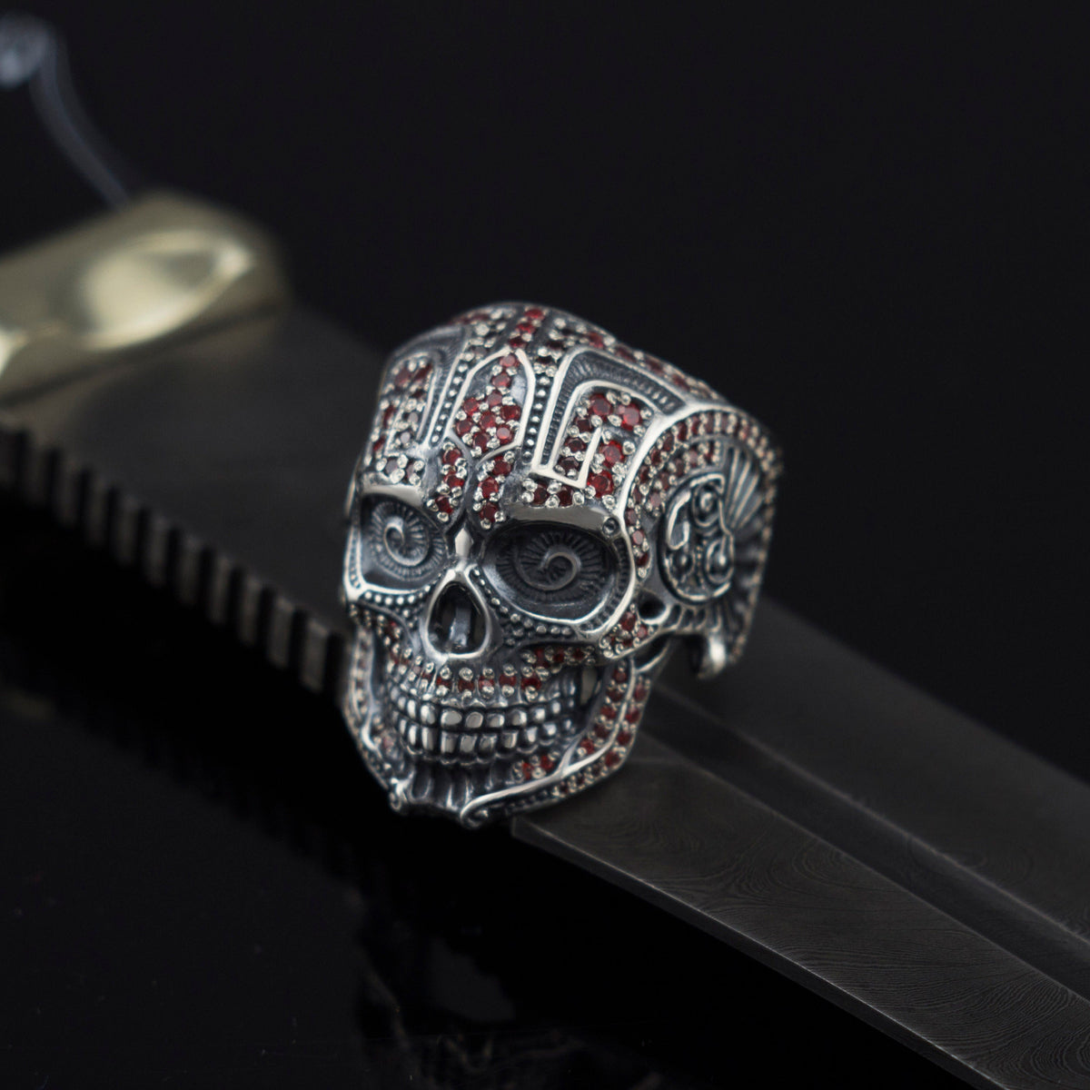 Mexican skull ring resting on black leather, angled view