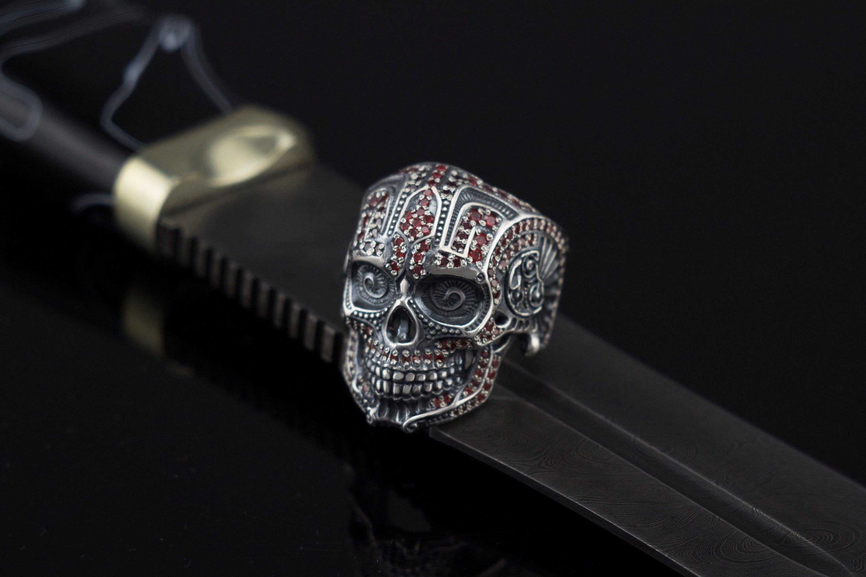 Sugar skull silver ring on a black leather strap, side view