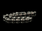 Mitchell silver skull chain laid out on black, full length view