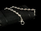 Mitchell skull wallet chain lying on a black textured wallet