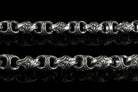 Close-up of Mokorr chain links with sculpted oxidized ornament and polished edges
