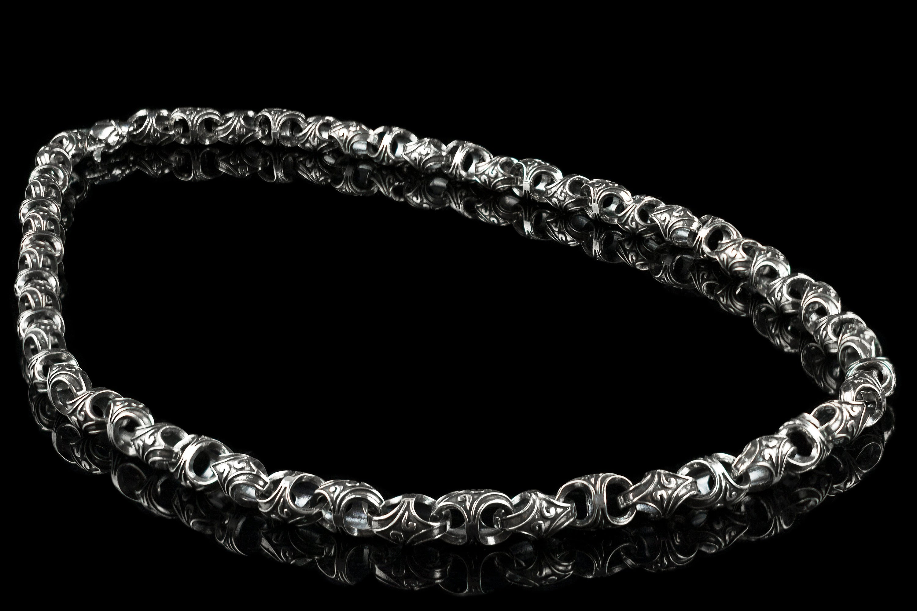 Mokorr heavy sterling silver chain for men laid in an oval on a black background