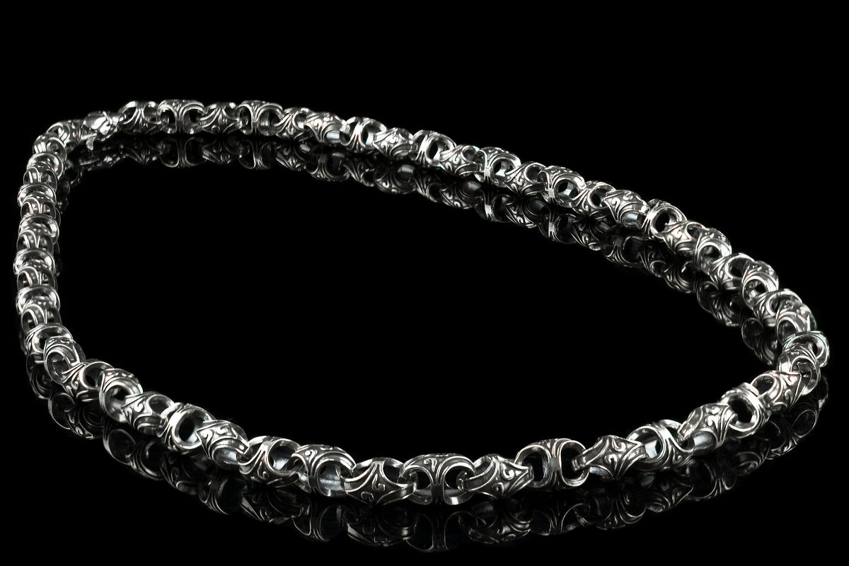 Mokorr heavy sterling silver chain for men laid in an oval on a black background