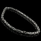 Heavy silver biker chain with ornate oxidized links, angled view on black