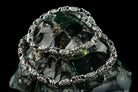 Ornate sterling silver chain draped in loops, showing oxidized link pattern