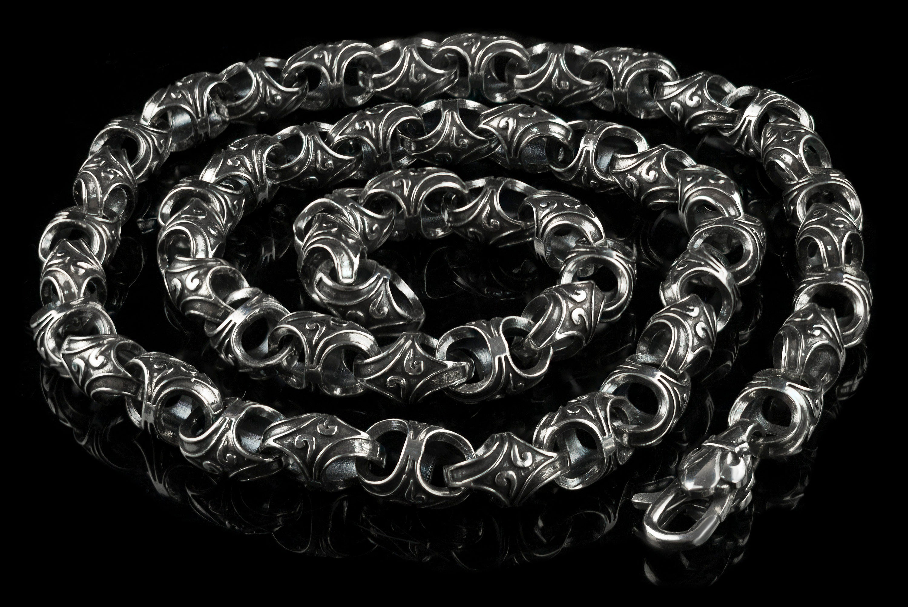 Mokorr sterling silver chain coiled in a spiral, showing the clasp and ornate links
