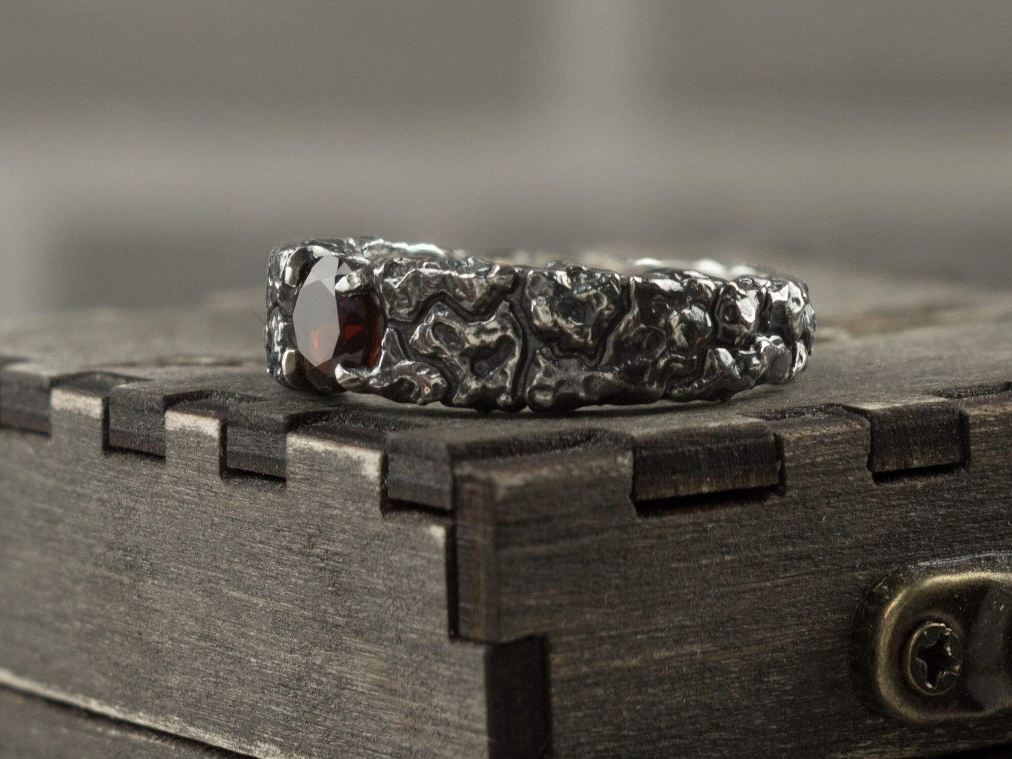 Close-up of the deep red garnet and rock-like silver texture