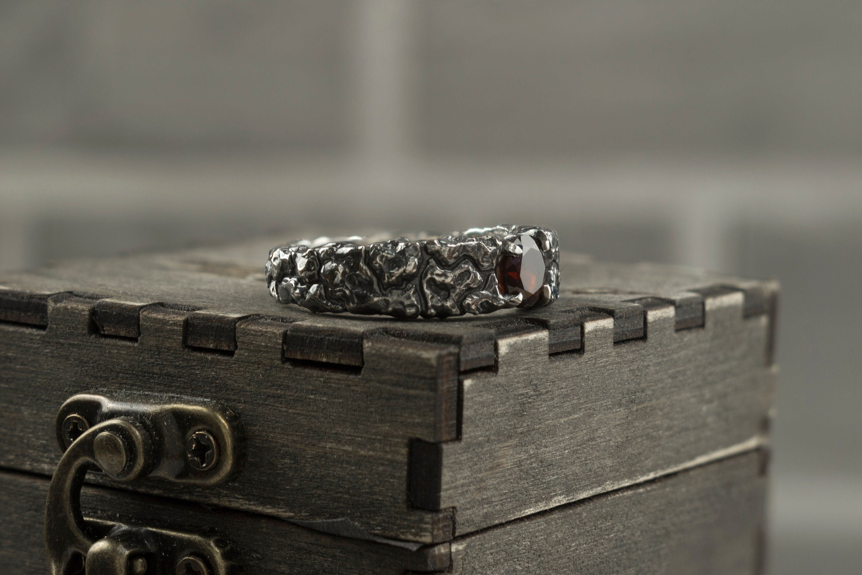 Mons Igneus men's garnet ring on a wooden box, other side