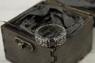 Mons Igneus ring standing in an open gift box, band and garnet